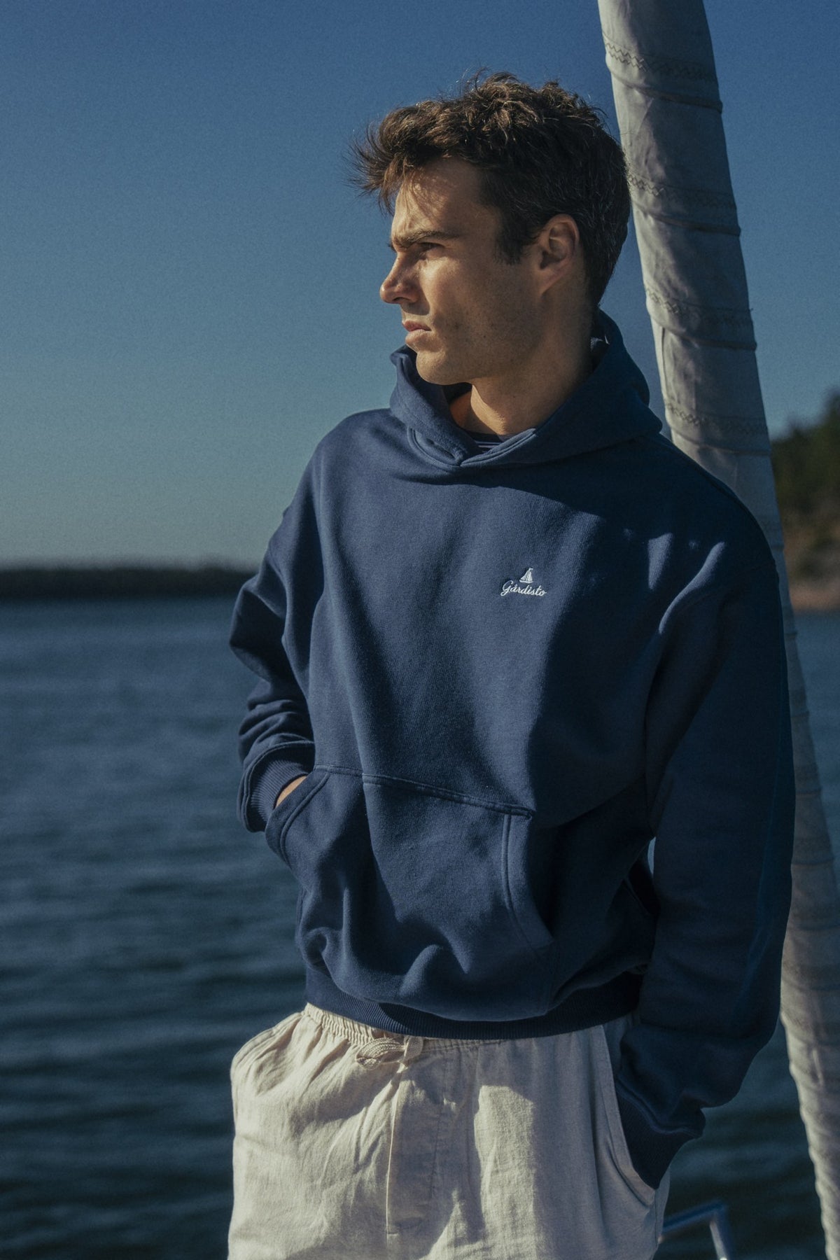 Person i en marineblå Gårdisto-hoodie på fordekket.